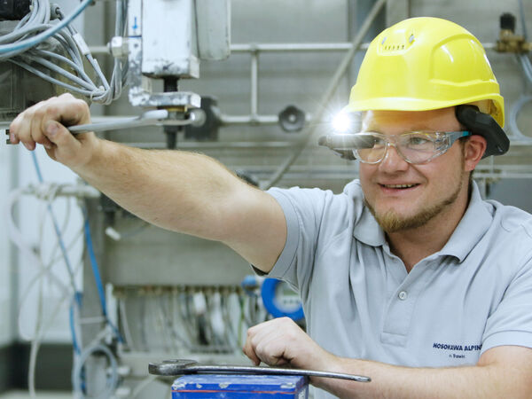 Un employé de Hosokawa Alpine effectuant la maintenance d’une machine.