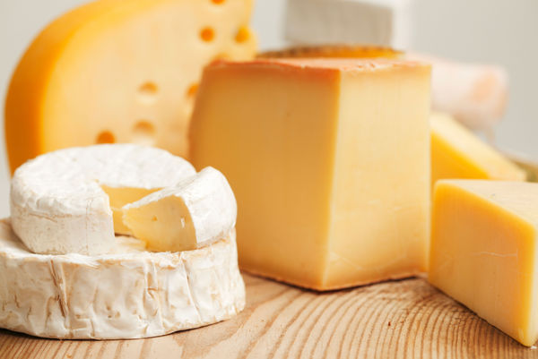 Different types of cheese on a wooden board 
