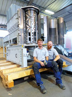 Deux hommes assis devant une machine Polyplex