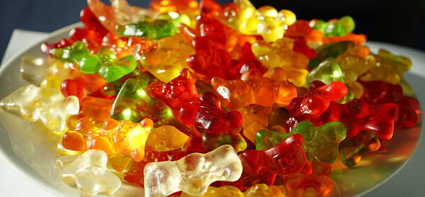 Une assiette de gommes aux fruits colorées de différentes couleurs comme le rouge, le jaune, le vert et l'orange.