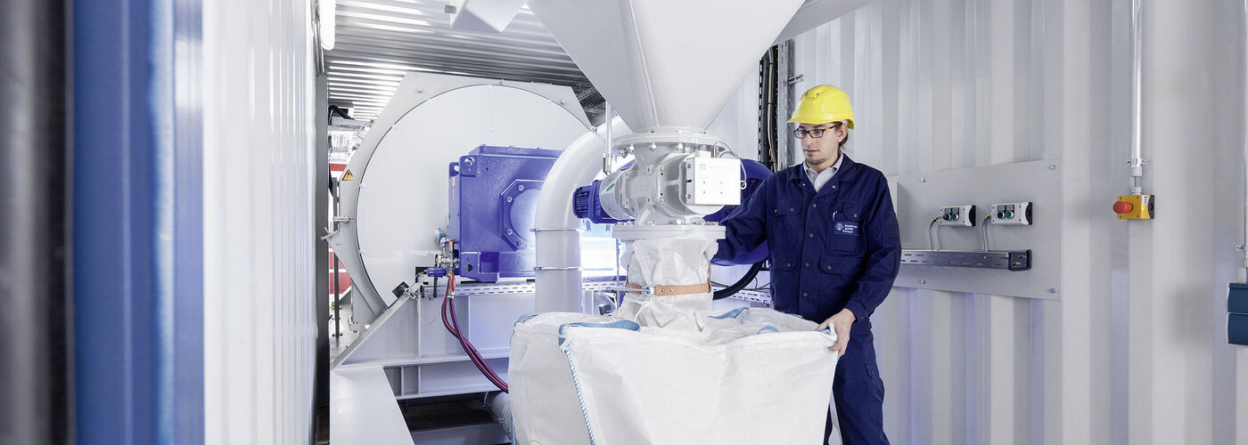 Un homme fait fonctionner une machine Hosokawa Alpine